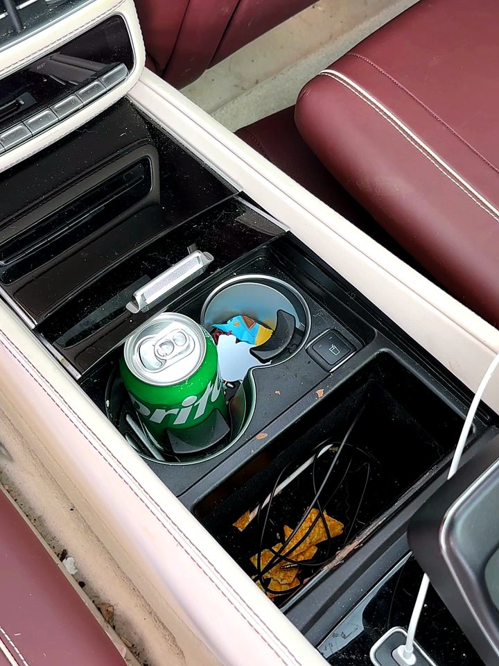Maybach rear center console with a soda can, crumbs and debris before an interior detail.