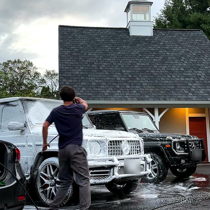 Tanner foaming down two Mercedes-AMG G63s in a customer's driveway.