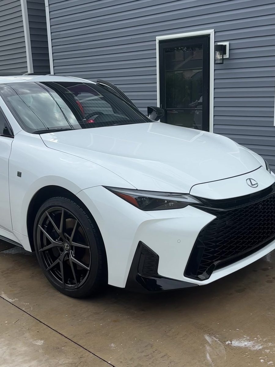 White Lexus IS sedan after an exterior detail in a driveway.