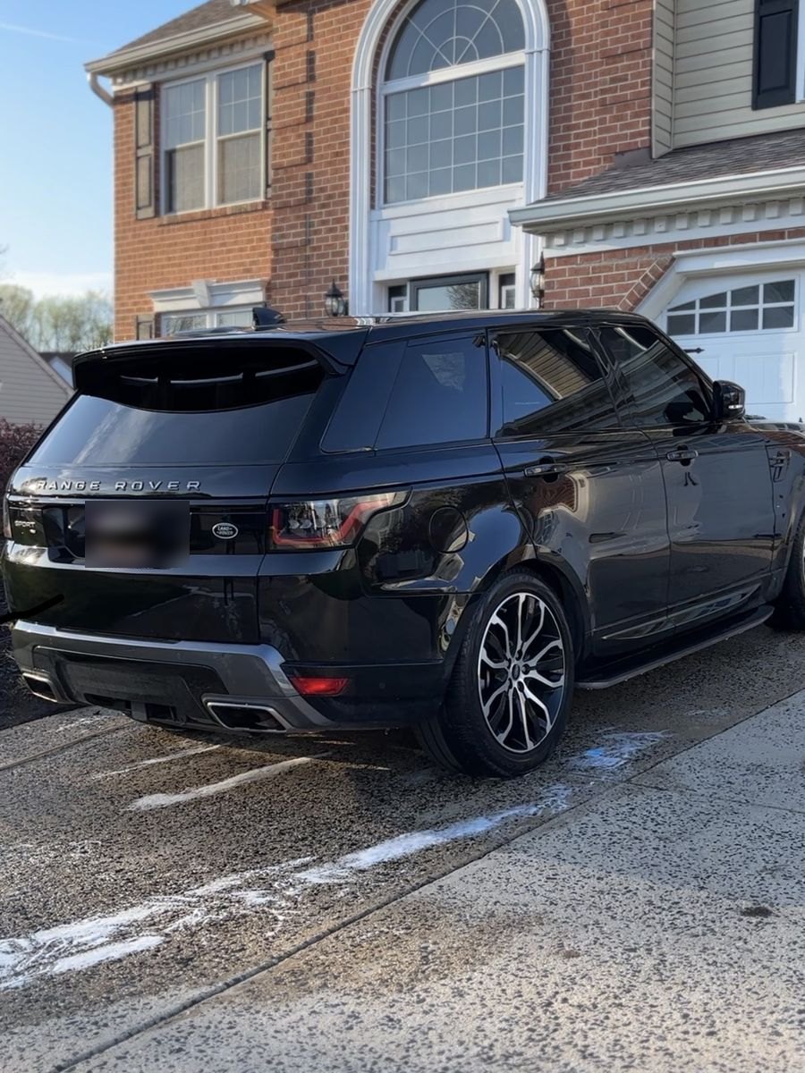 Black Range Rover Sport after an exterior detail in a home driveway.
